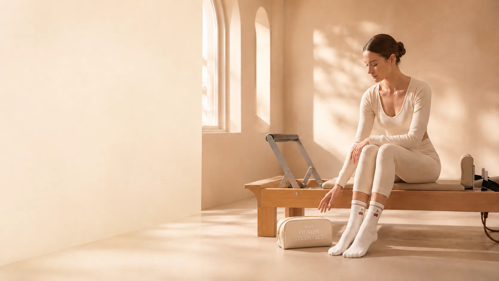 Soft Stone Aramé Pilates Studio Set bag beside a model on a reformer